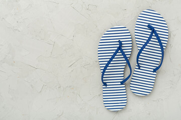 Striped blue flip flops on concrete background, top view