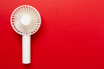 Mini electric fan on color background, top view
