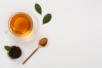Cup of tea with dry and fresh leaves on color background, top view