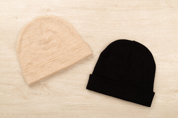 Stylish beanie hat on wooden background, top view