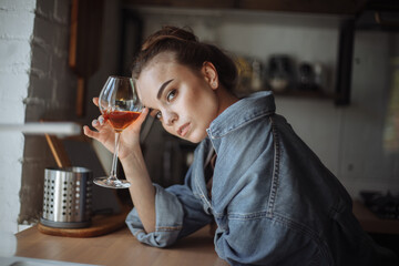 Young Woman with Glass of Red Wine in Kitchen