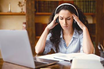 Tired Student Or Worker. Exhausted stressed young woman suffering from migraine, touching and...