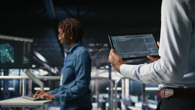 Close up of data center programmer looking at code debugging tools running on tablet. Server farm IT professional checking machine learning script automating tasks, camera A