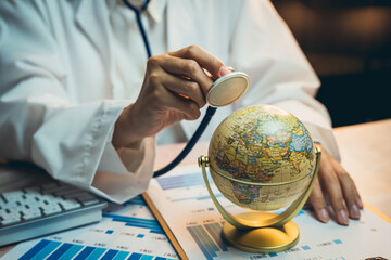 Medical concept. Doctor examining globe with stethoscope on charts in healthcare and global health concept for stock photo website