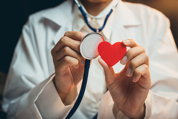 Health care concept. Doctor Holding Stethoscope and Red Heart Cutout Symbolizing Care for Health...