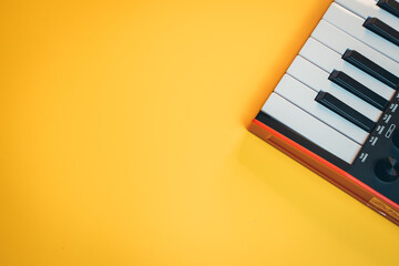 Close-Up of a Keyboard on a Bright Yellow Background for Music Composition and Creative Projects