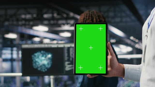 Close up of data center employee doing maintenance tasks on isolated screen tablet, ensuring optimal performance. Worker using chroma key device to review diagnostics and apply patches