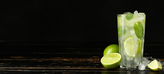 Glass of tasty mojito on dark background