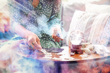 Young witch with magic attributes on table at home, closeup