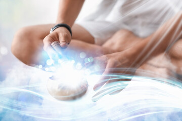 Young man with Tibetan singing bowl at home, closeup