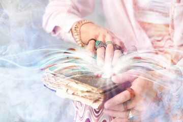 Woman with old book and dream catcher, closeup