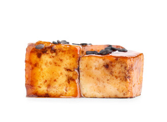 Pieces of fried tofu cheese with soy sauce and black sesame seeds on white background