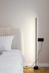 Floor led lamp near the bed in the bedroom