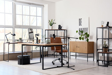 Interior of blogger's office with workplace and shelf units