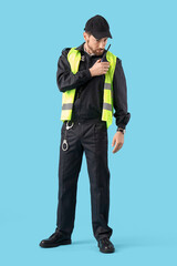 Male traffic police officer with radio transmitter on blue background