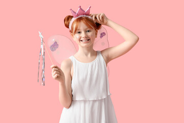 Cute girl in fairy costume with magic wand on pink background
