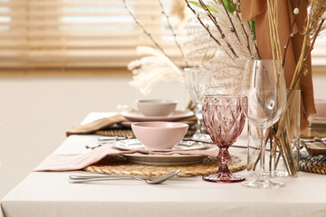 Elegant table setting with beautiful flowers, pampas grass and willow branches in stylish dining...