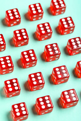 Red game dices on turquoise background, closeup
