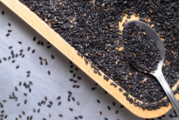 Black sesame seed in spoon and wooden plate, Healthy eating, Top view