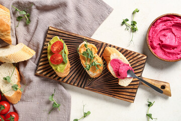 Composition with tasty sandwiches, hummus and fresh sprouts on light background