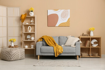 Interior of living room with sofa, shelving units and beautiful daffodils bouquets in vases