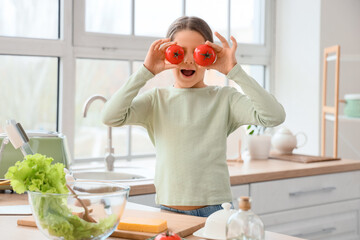Cute girl with red tomatoes in kitchen