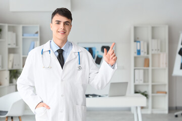 Handsome doctor pointing at something in clinic