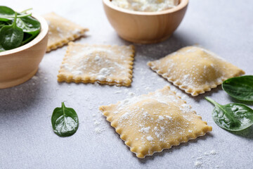 Uncooked ravioli, cottage cheese and spinach on light table, closeup