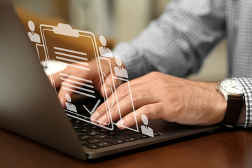 Human resources manager working on laptop at table, closeup. Candidate's resume on virtual screen above computer. Recruitment and employee search