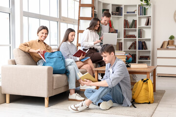 Group of students with books studying in library