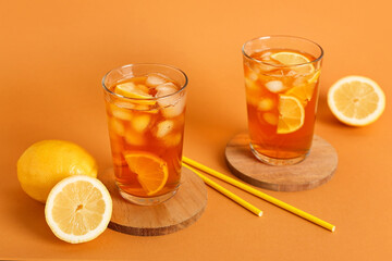 Glasses of fresh iced tea on orange background