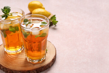 Glasses of fresh iced tea on light background