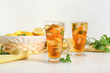 Glass cups of fresh iced tea on light background