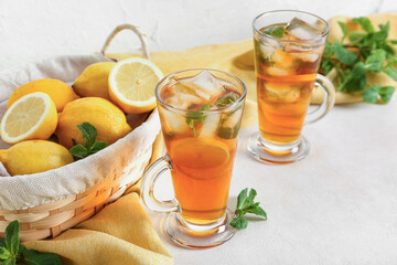 Fototapeta premium Glass cups of fresh iced tea on light background