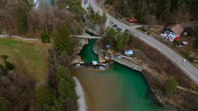 Lechfall, stunning waterfall in Fussen, Bavaria, captured from a high-angle drone shot. The scenic bridge, crystal-clear river, and picturesque landscape make it a perfect travel and photography spot