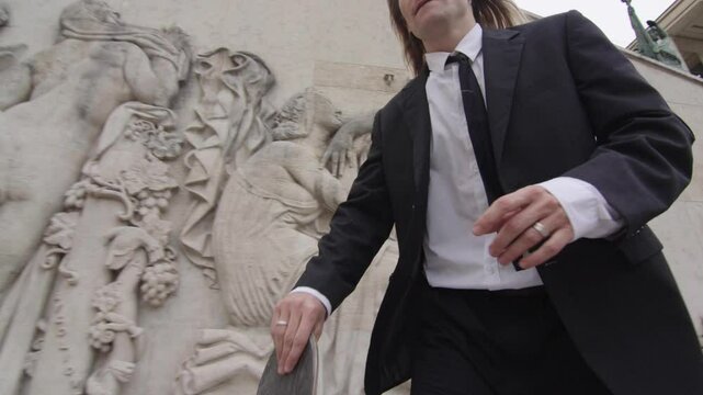 Businessman walking and skateboarding in suit