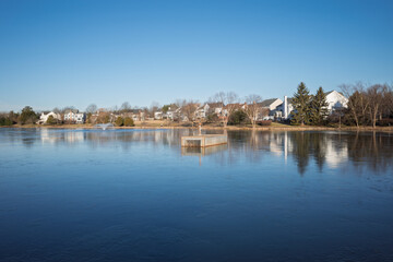 Early winter morning sun over frozen pond with water fountain in Ashburn, Virginia, USA