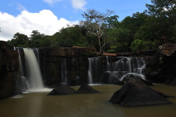 Naklejka premium Tat Ton is a beautiful waterfall with water flowing all year round, On top of it, the water cascades down wide rock plateaus, with big trees lining up on both side of the stream Chaiyaphum ,THAILAND