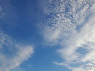 A calm blue sky filled with soft, scattered clouds, creating a peaceful and serene atmosphere.

