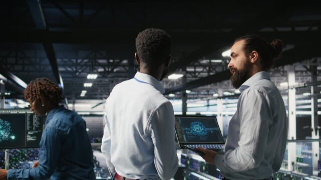 Server farm coworkers doing infrastructure AI machine learning automatization. Data center computer scientists collaborating to maintain servers using artificial intelligence, camera A