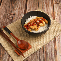 Rice bowl with chicken katsu and topped with sauce and sesame seeds
