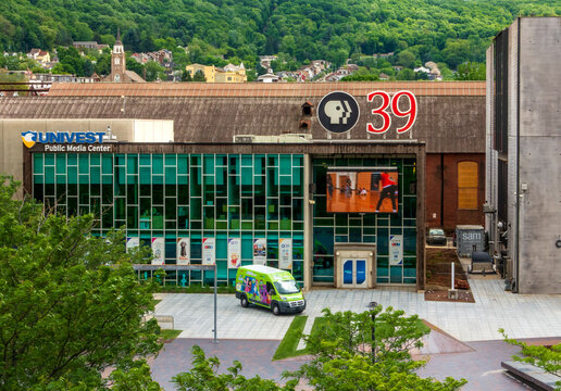 Bethlehem, PA - US - May 25, 2025 The Univest Public Media Center, home to PBS 39, features a modern glass facade with a vibrant outreach van parked in front, nestled in scenic Bethlehem, PA.