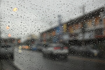 rain in the city blur background, water drop on windshield of car
