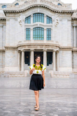 Fototapeta premium Happy Latina woman with braided hair smiling in front of Palacio de Bellas Artes. Her traditional blouse and vibrant look represent culture and pride in Mexico City.