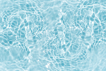Blue water with ripples on the surface. Defocus blurred transparent blue colored clear calm water surface texture with splashes and bubbles. Water waves with shining pattern texture background.