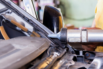 Car repair service, technician uses silicone to stick on the windshield