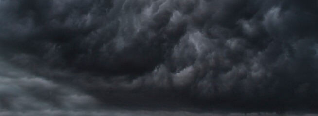 Obraz premium Banner Dramatic dark storm clouds black sky background. Dark thunderstorm clouds rainny season. Panorama Meteorology danger windstorm disasters climate. Dark cloudscape storm cloud with copy space.