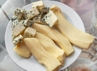 Blue cheese with noble mold, diced, on a plate, top view