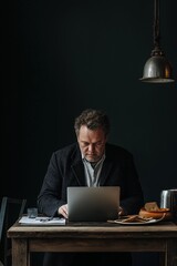 Focused man using laptop during lunch break in studio