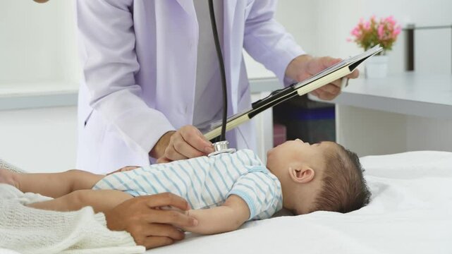 Asian loving mother comforts her three-month-old, as a male doctor administers essential childhood vaccinations, ensuring the baby's healthy future in a calm, professional setting.